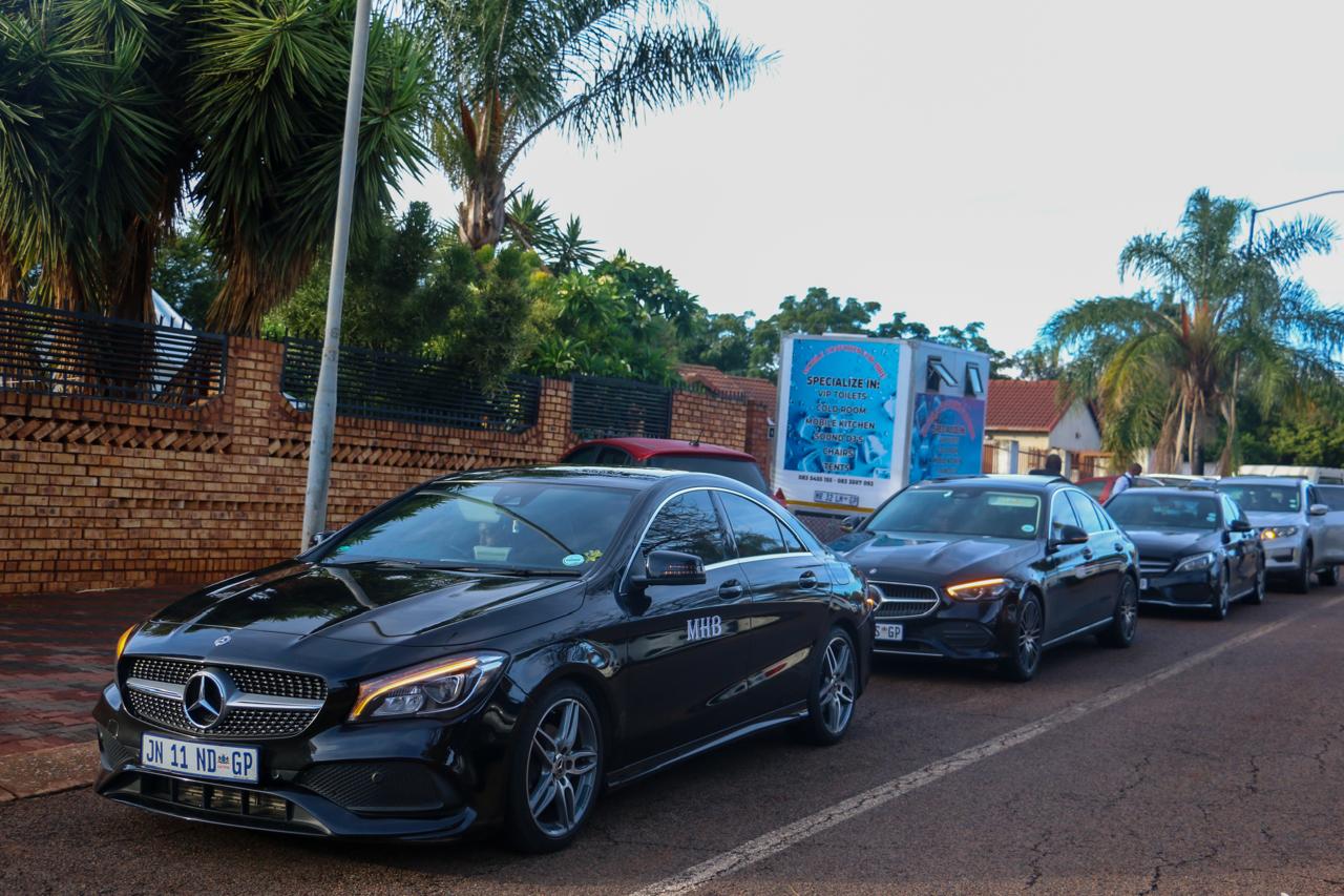 Row of black MHB branded Mercedes-Benz family cars ready for a funeral