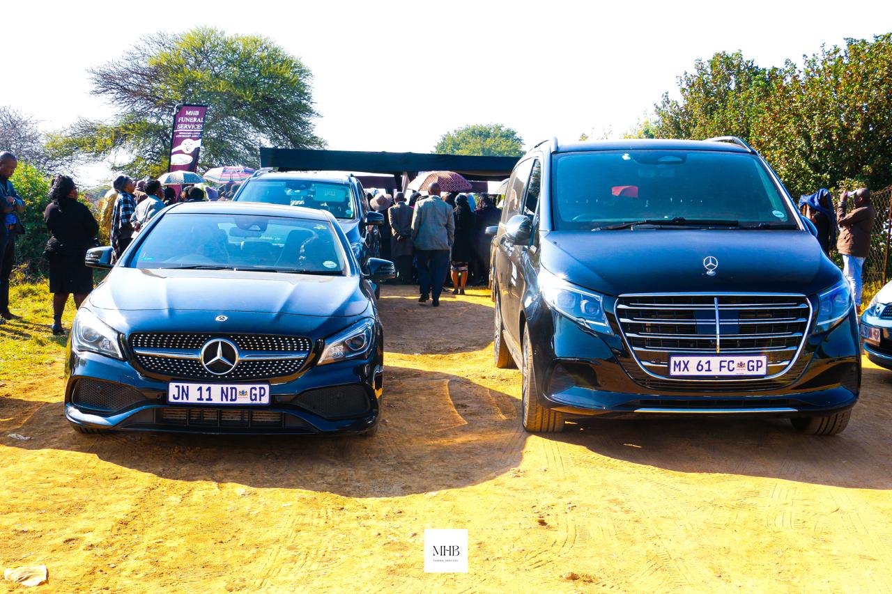 MHB branded vehicles and banner at a graveside gathering